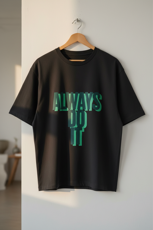 Black t-shirt with 'ALWAYS DO IT' text in green on a hanger against a neutral wall.