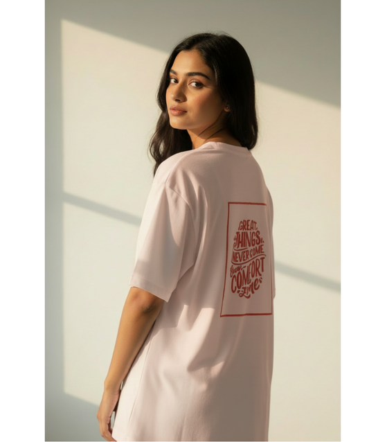 Woman wearing a light pink t-shirt with a red text design on a neutral background