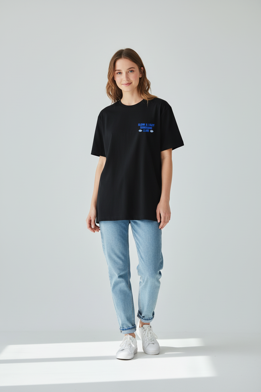 Person wearing a black t-shirt with text and light blue jeans on a white background